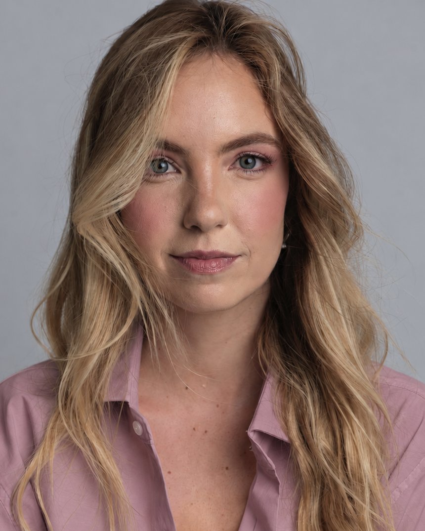 Mujer rubia de ojos claros con camisa malva rosada, con luz suave